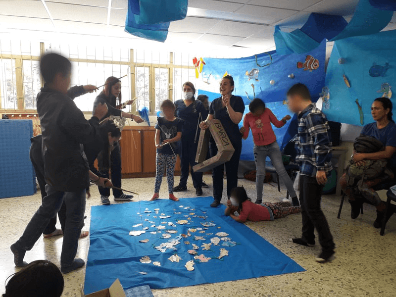 niños y niñas jugando en la sala de la universidad pedagógica